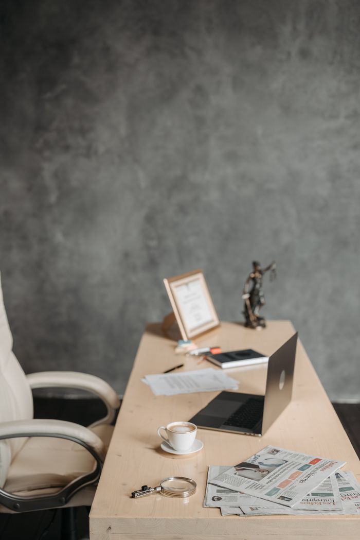 services-05 Minimalist office desk with laptop, coffee, and decor for a professional setting.